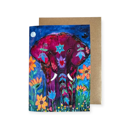 5 x 7 inches greeting card, featuring a female elephant, her colors are pinks and fuchsias, she is surrounded by giant sunflowers and a sky with stars and a full moon. Perfect to give to a person you care